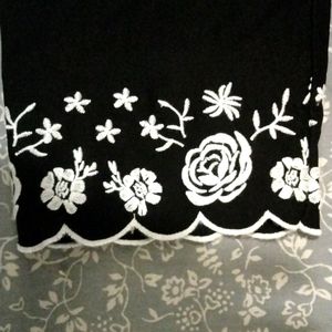 Black skinny ankle cut dress pants with pretty floral embroidery at the bottom.